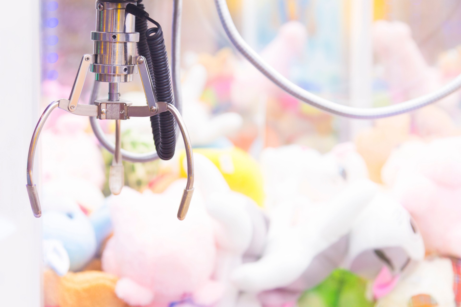Claw Game or cabinet catches the doll.A mechanical arm selecting a random soft toy in a vending machine